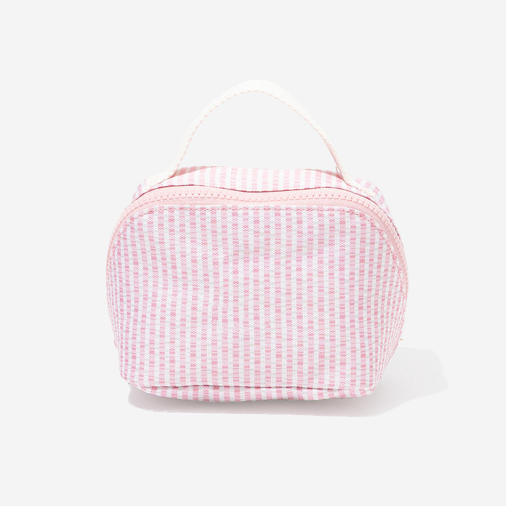 pink seersucker makeup bag in hand