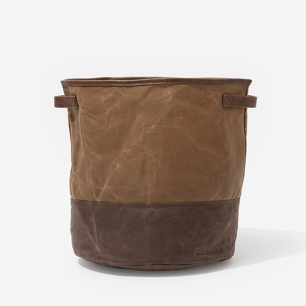 waxed canvas storage basket with blankets hanging out