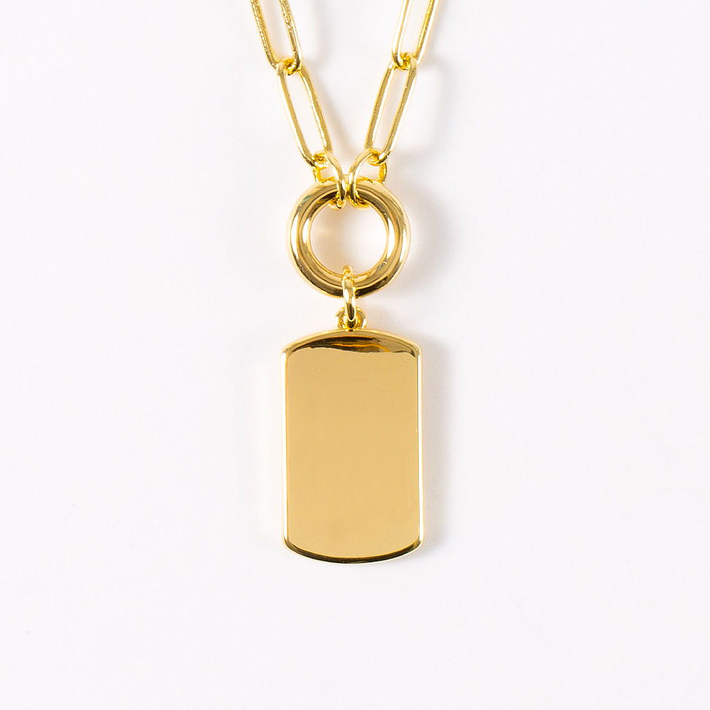 close up of monogramed tag on necklace