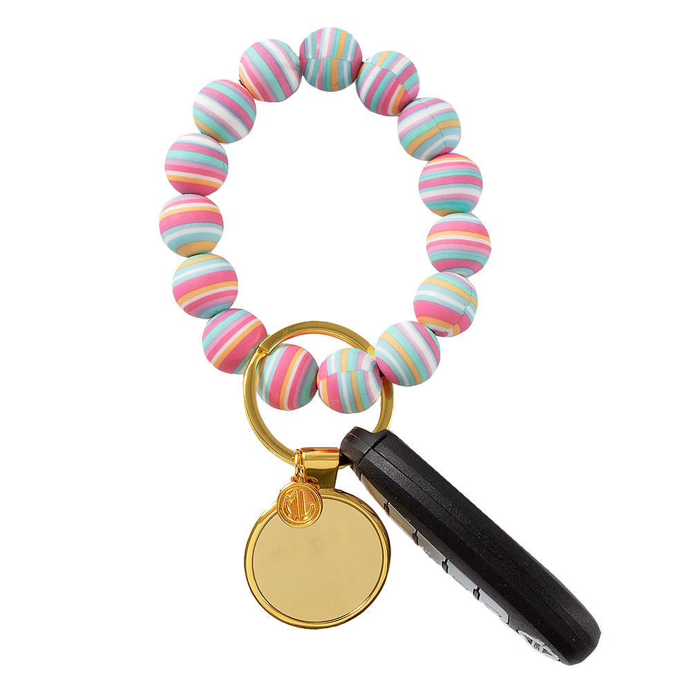 girl holding rainbow stripe key ring