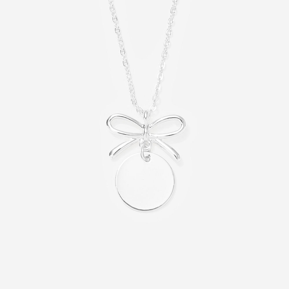 Silver bow necklace on marble with ribbon