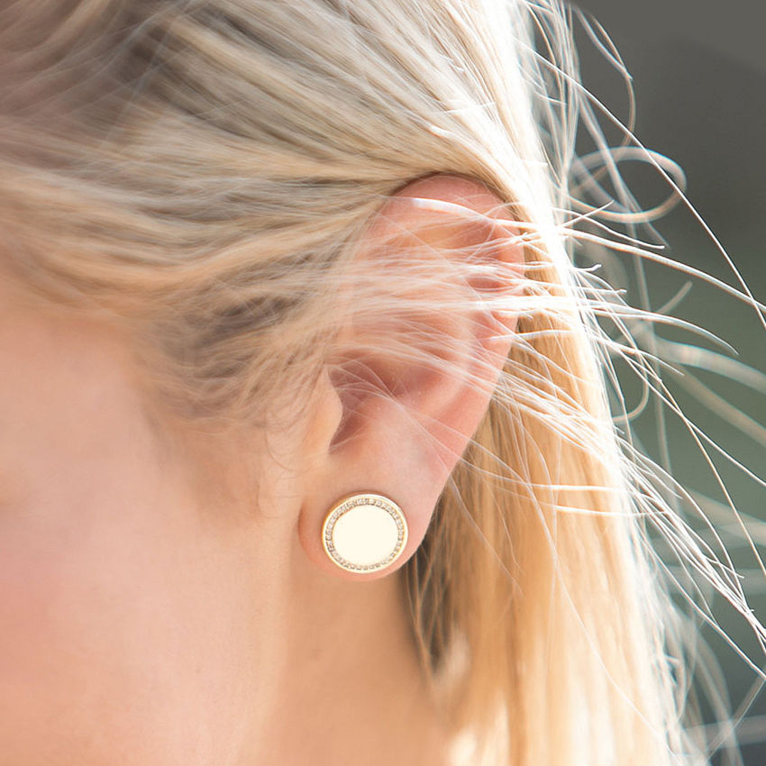 silver monogrammed disc earrings on brunette