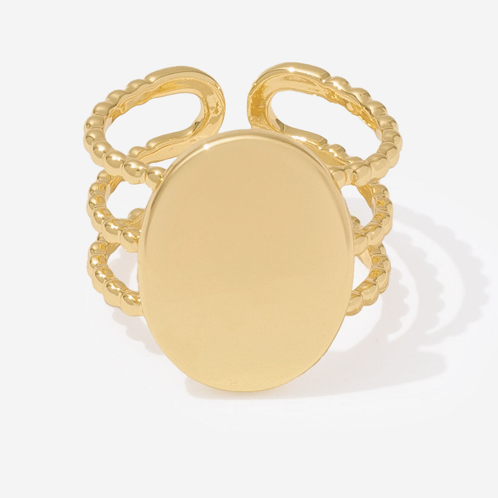 golden statement monogrammed ring on finger