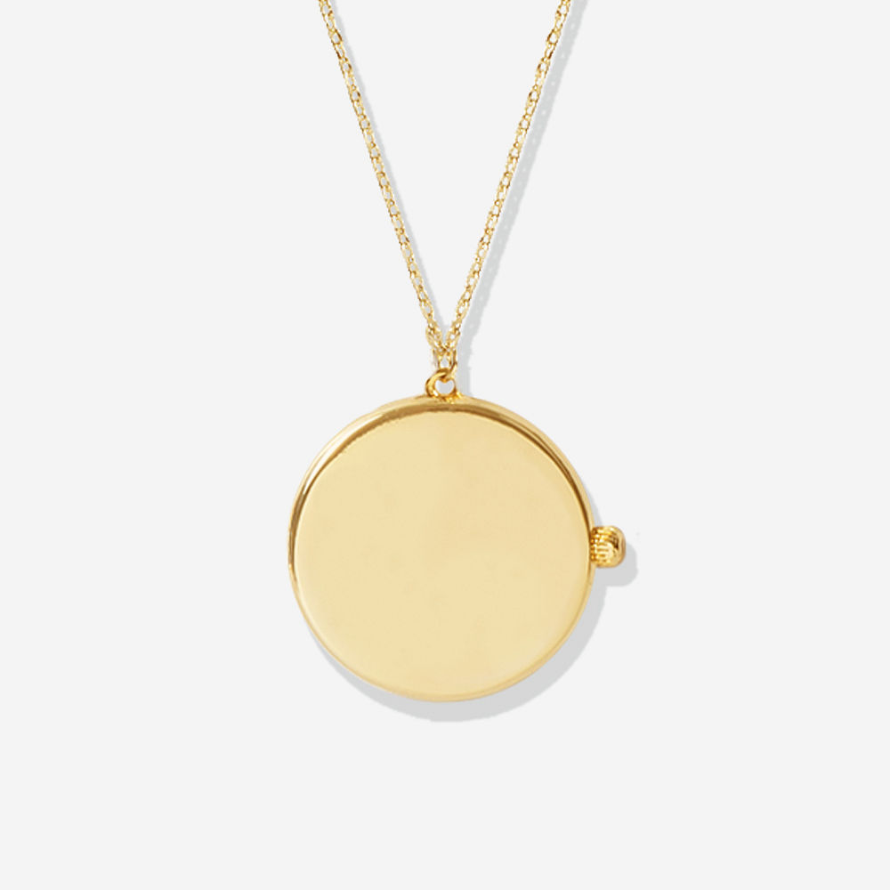 gold circular locket pendant in hand