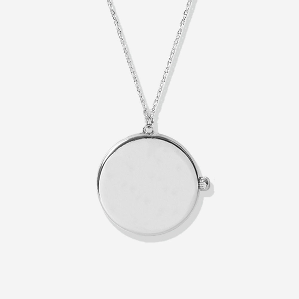 gold circular locket pendant in hand