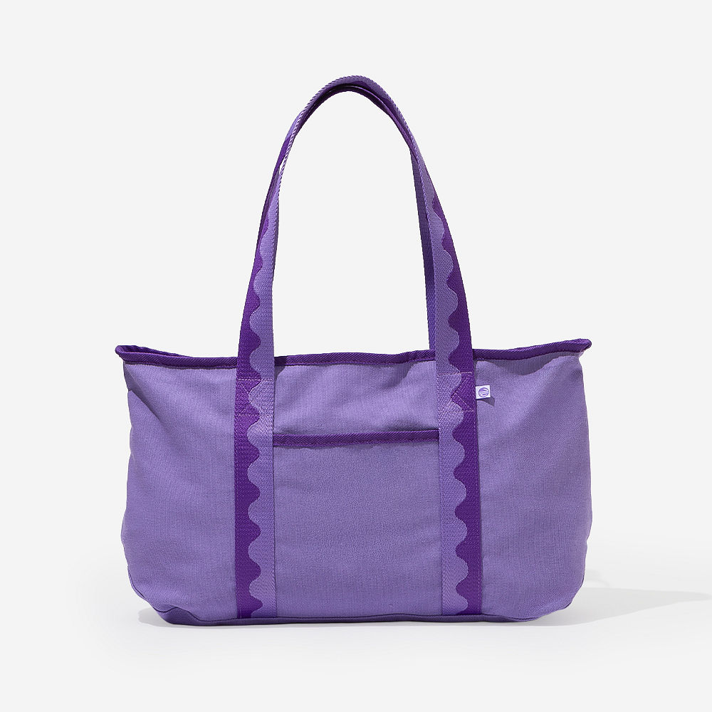 purple anywhere tote bag on bench with flowers