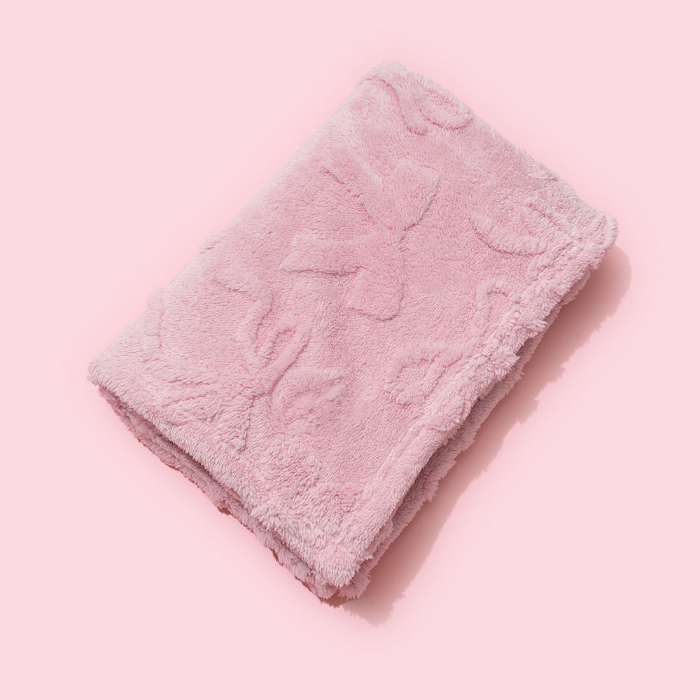 pink baby blanket on crib