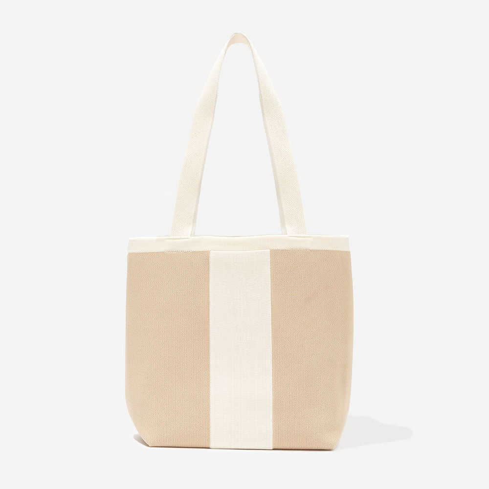 monogrammed tan ivory knit tote at angle in studio