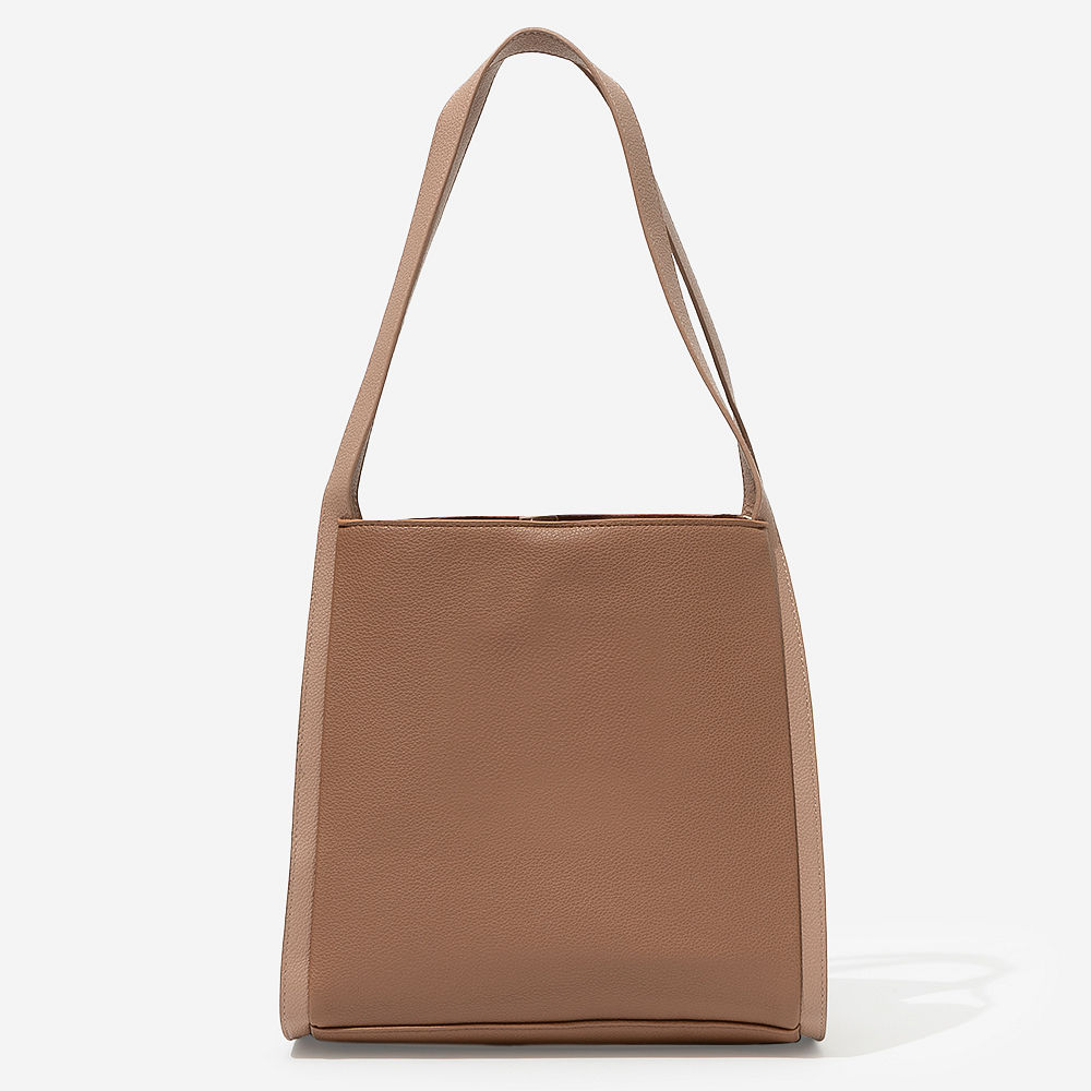 girl holding monogrammed shoulder tote in brown