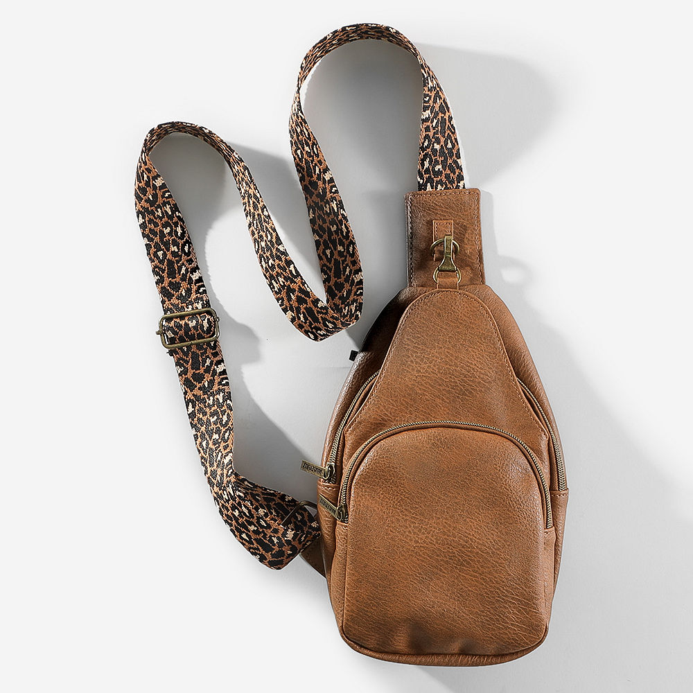 close up of girl wearing taupe sling purse