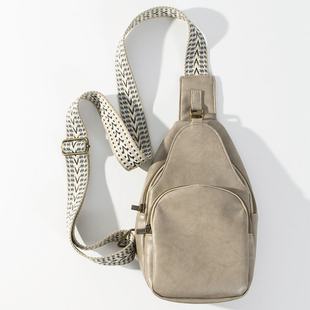 close up of girl wearing taupe sling purse