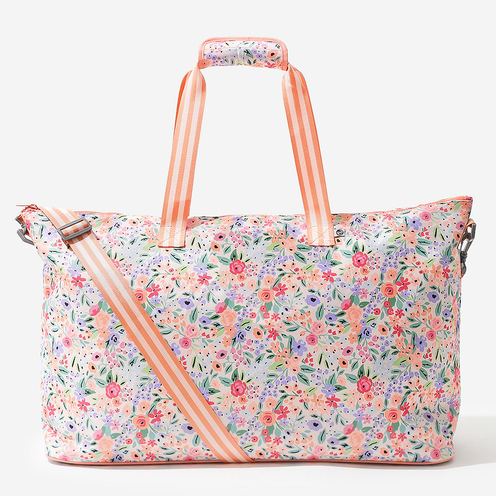 Personalized coral floral weekend bag on a bench