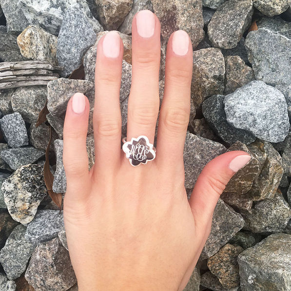 girls hand wearing silver quatrefoil ring