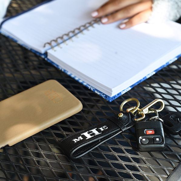 black monogrammed leather keychain on a table