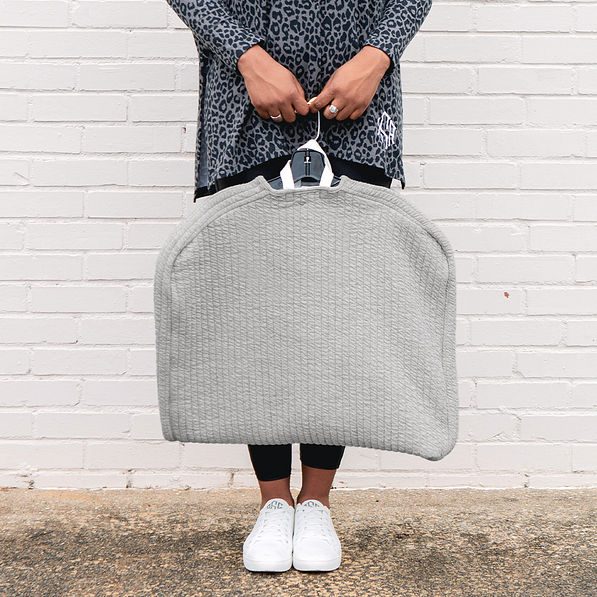 girl holding monogrammed quilted garment bag