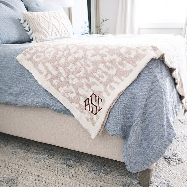neutral leopard personalized cozy blanket on bed
