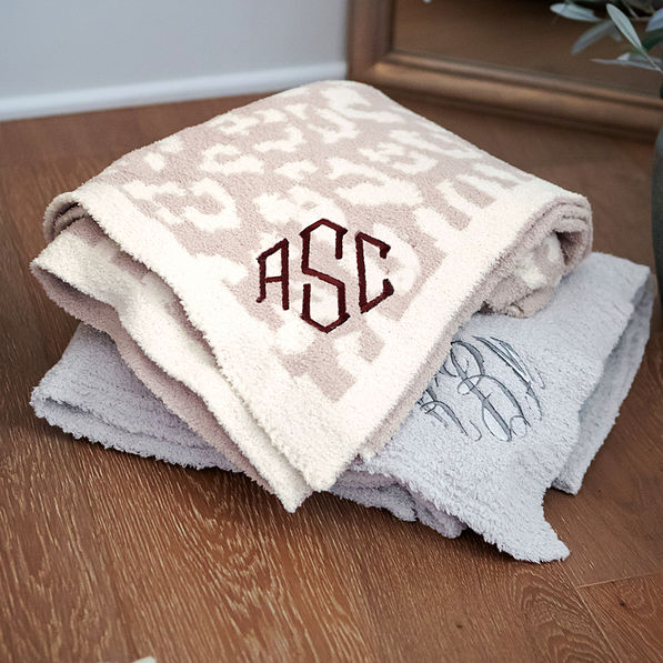 personalized cozy blanket in neutral leopard on top of grey cozy blanket