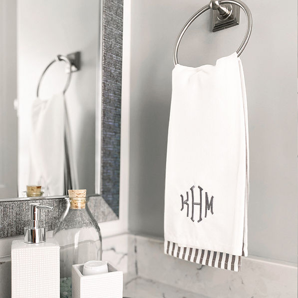 Gray hand towel set hanging in powder room