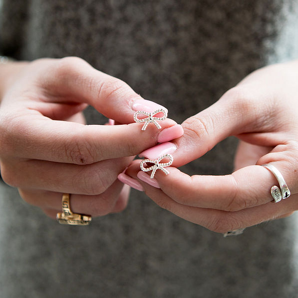 bow earrings in hands