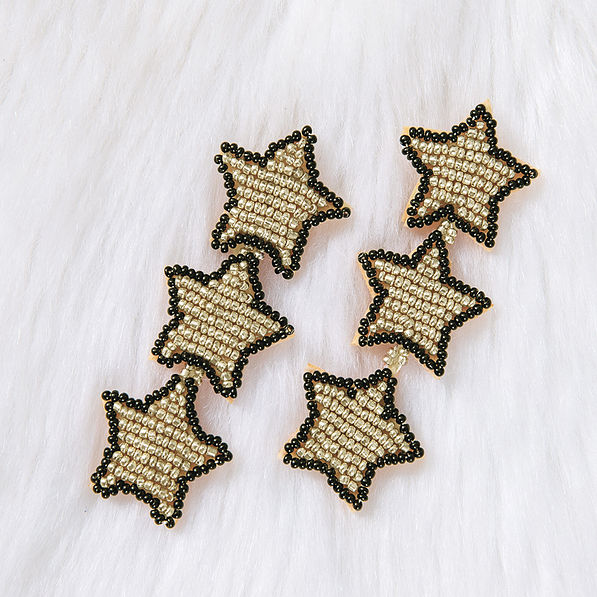 star earrings on fuzzy white rug