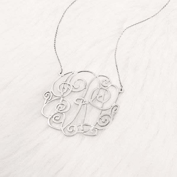 close up of silver monogrammed lacey necklace
