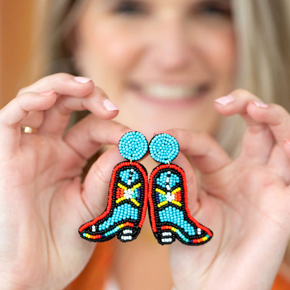 cowboy boot earrings in hands