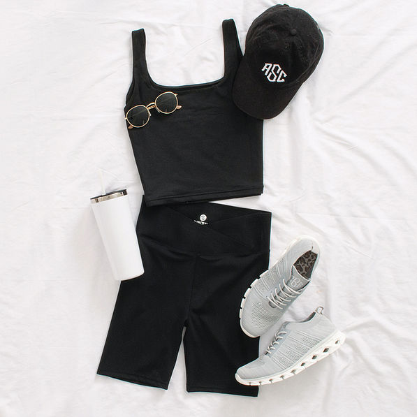 crossover bike shorts styled with sneakers, baseball hat, sunglasses, and tumbler