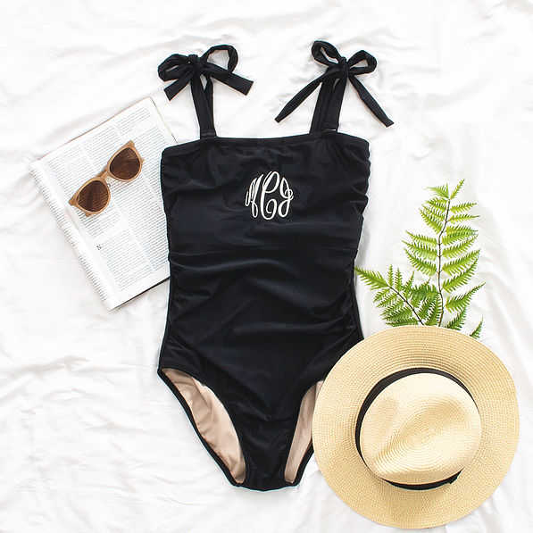 black one piece bathing suit flatlay
