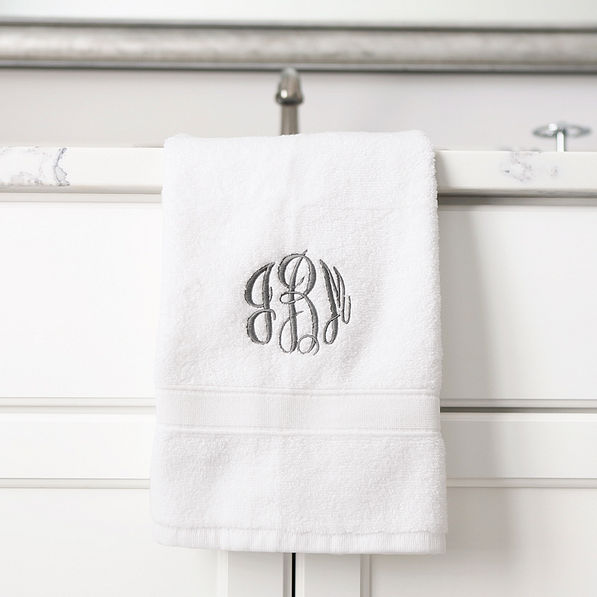 white hand towel hanging off the sink