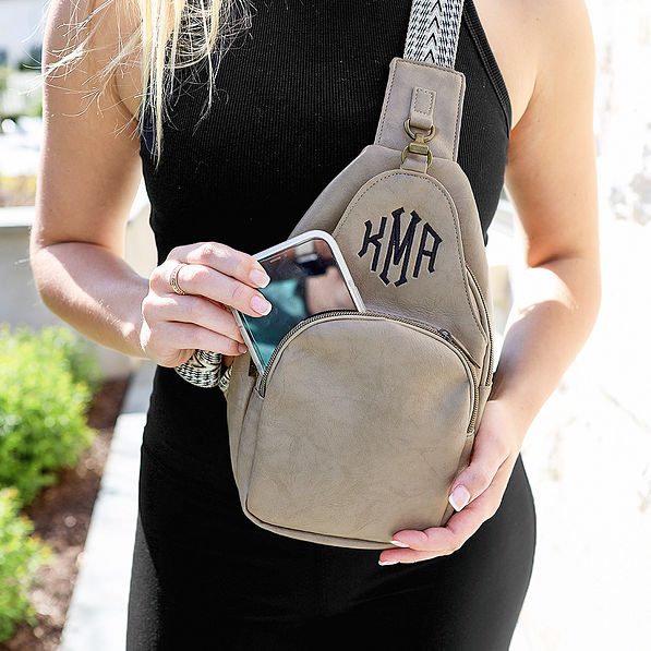 close up of girl wearing taupe sling purse