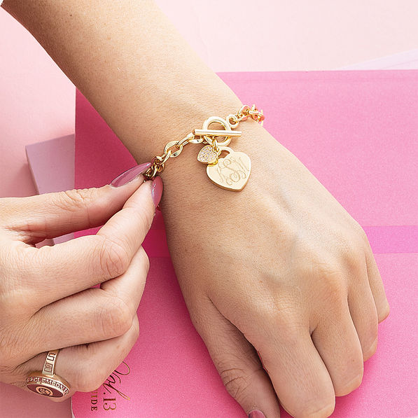 girl wearing monogrammed heart bracelet in gold