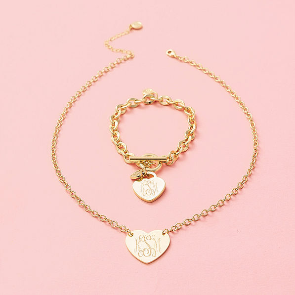monogrammed heart bracelet and necklace in gold on pink