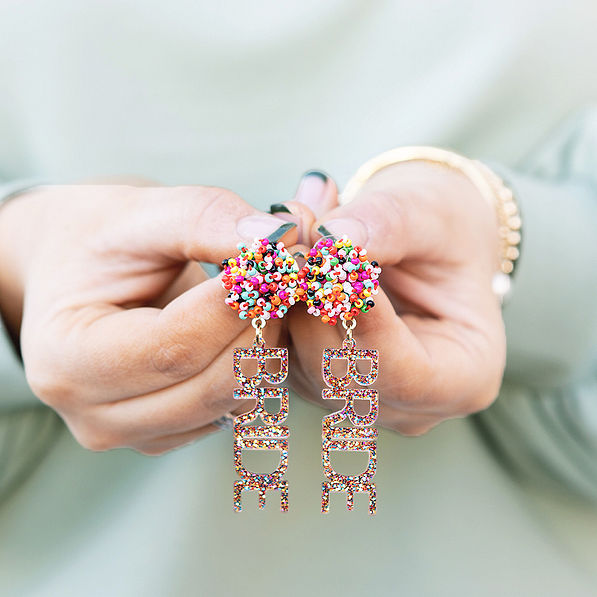 close up of girl holding bride earrings