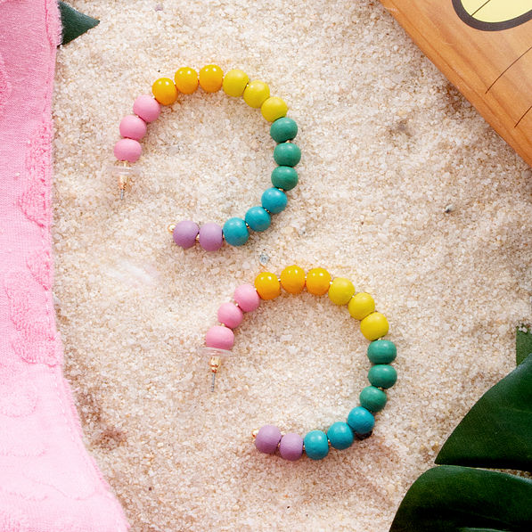 rainbow beaded hoop earrings on sand