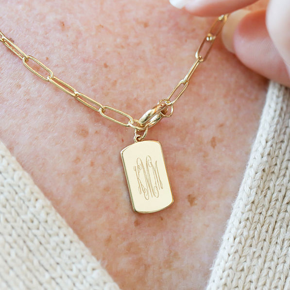 close up of monogramed tag on necklace