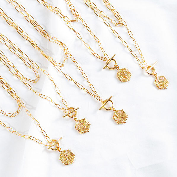 assorted initial layered necklaces on shet