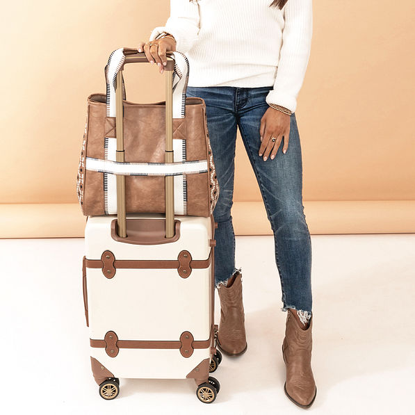 neutral aztec purse tote on suitcase