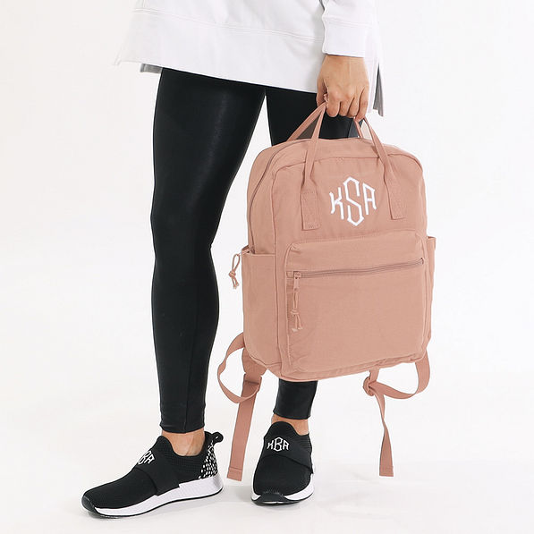 holding monogrammed blush canvas backpack