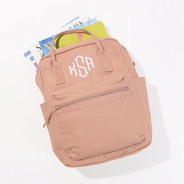 monogrammed canvas blush backpack with books and magazines inside