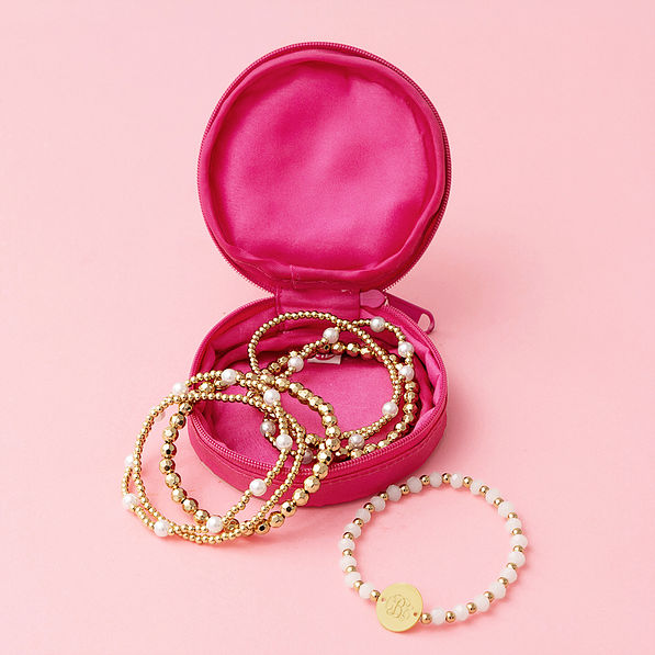 hot pink travel jewelry case with gold beaded bracelet stack