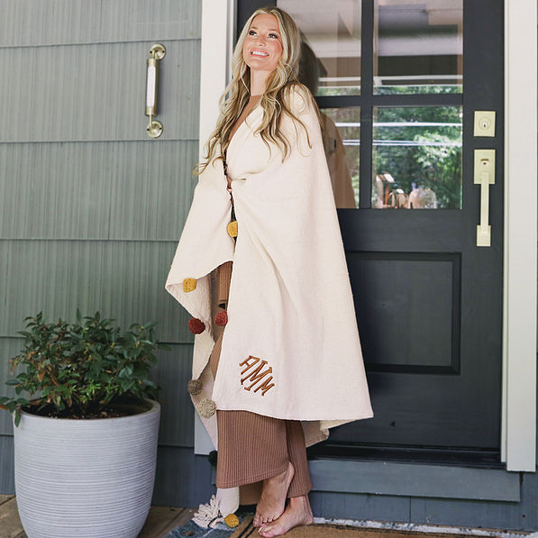 monogrammed pom pom blanket wrapped around