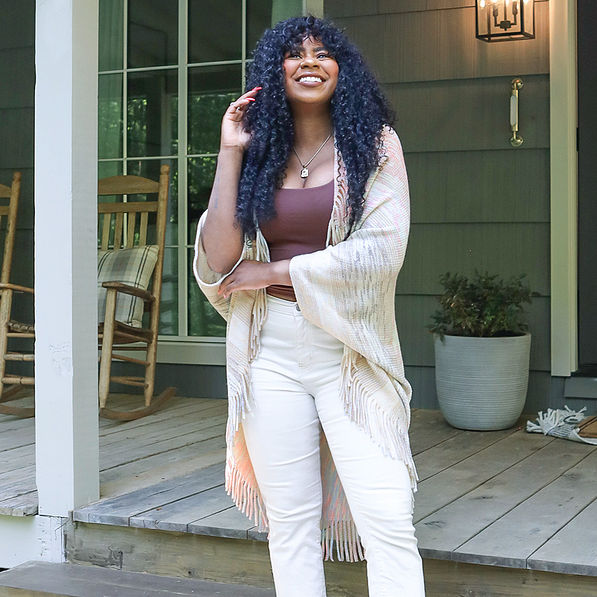 model wearing khaki fringe cardigan on porch