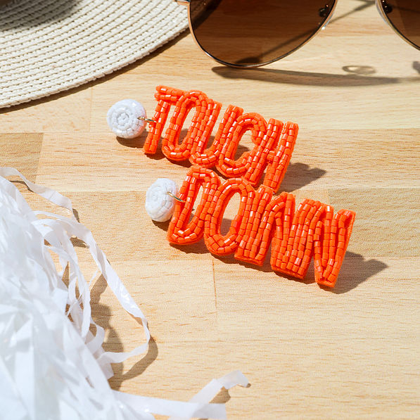 Close up of orange touch down earrings