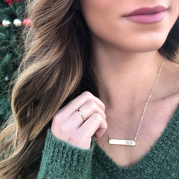 gold monogrammed bar necklace with green sweater