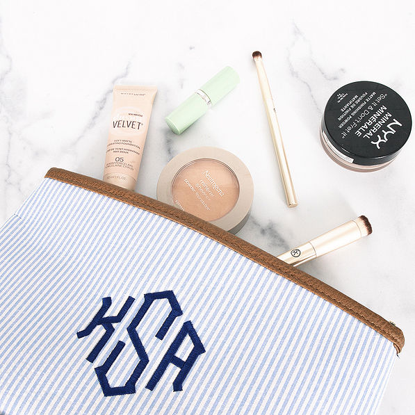monogrammed seersucker cosmetic bag with makeup spilled out