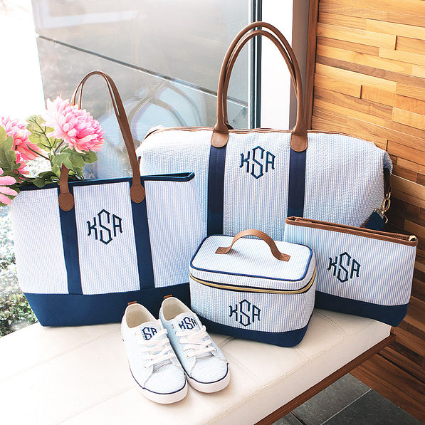 monogrammed navy seersucker travel collection on bench