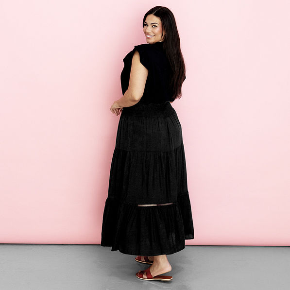 black midi skirt on Julia in front of pink paper