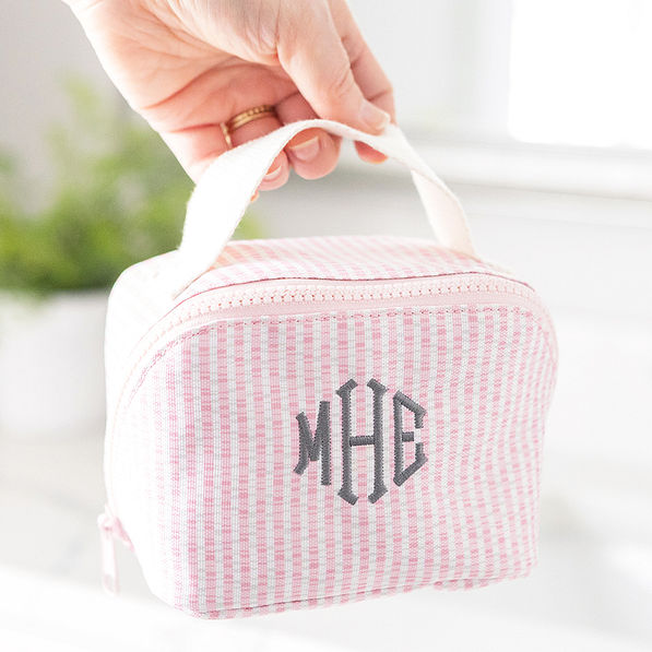 pink seersucker makeup bag in hand