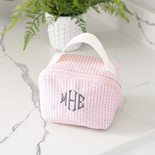 pink seersucker makeup bag on bathroom counter