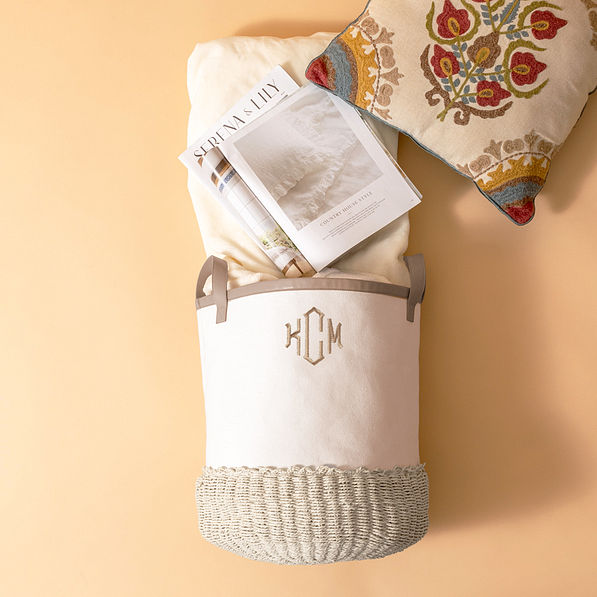 tan and ivory storage basket with blankets and magazines